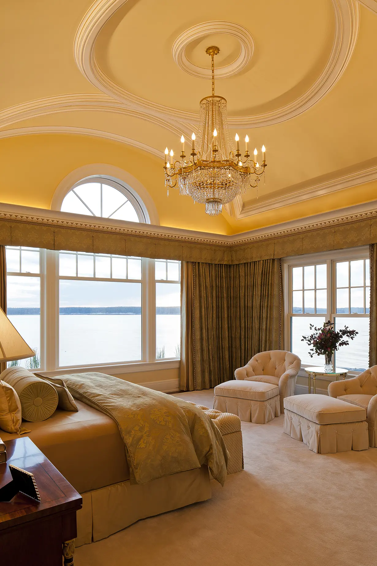 Primary bedroom with molded ceiling and view of ocean