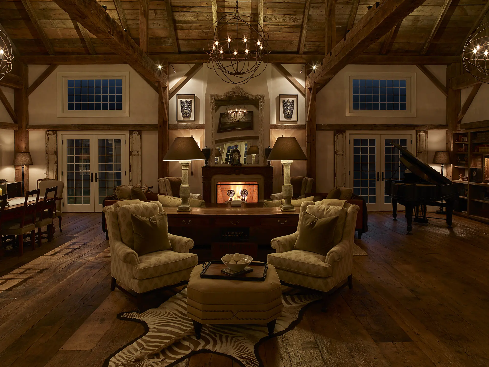 View of the spacious living area showing exposed beams and large fireplace