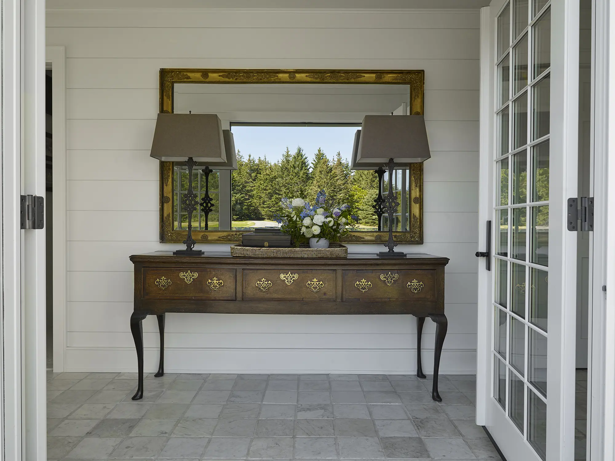 Entryway with large credenza and mirror reflecting the outdoors