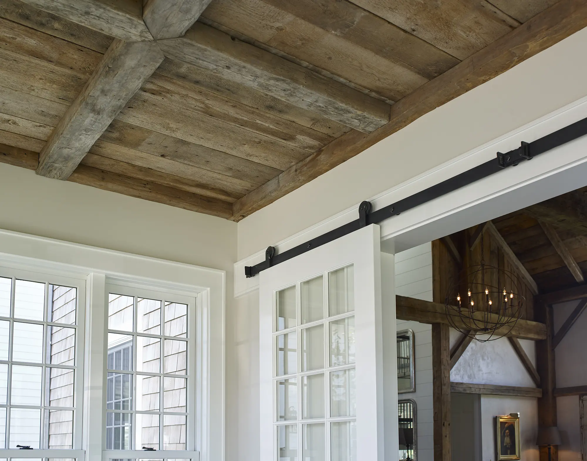 View of exposed beams on ceiling and sliding door to living area