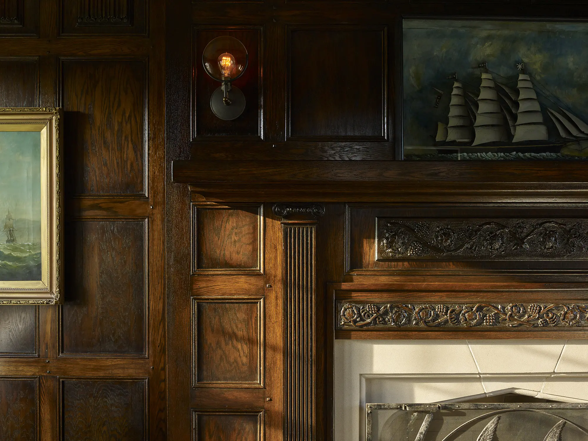 Detail of wood paneled walls and hand carved mantle
