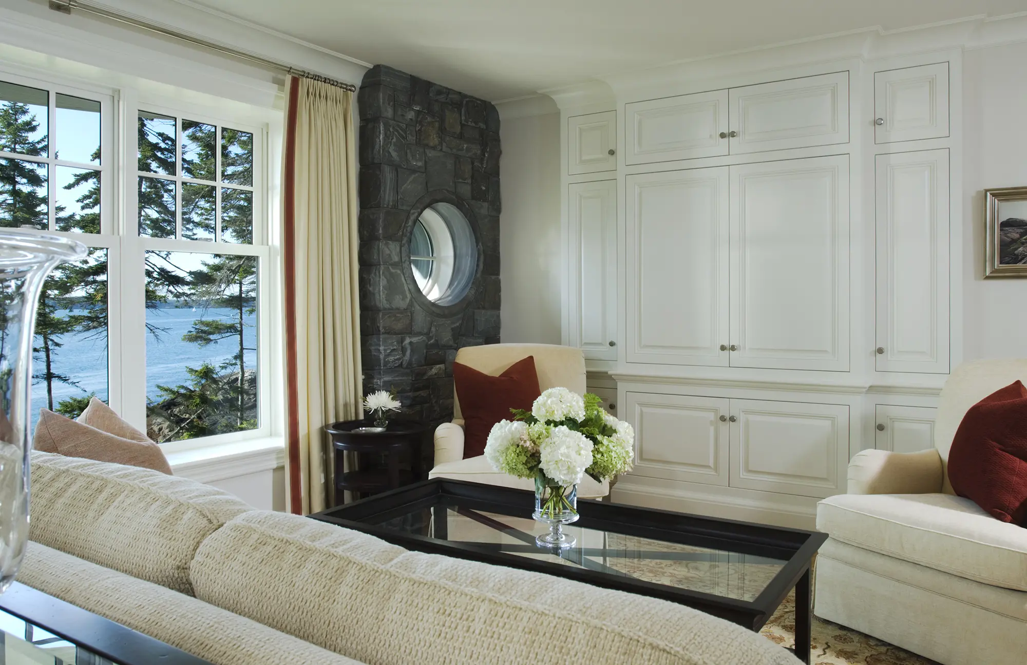 Living room with custom cabinetry and stone wall