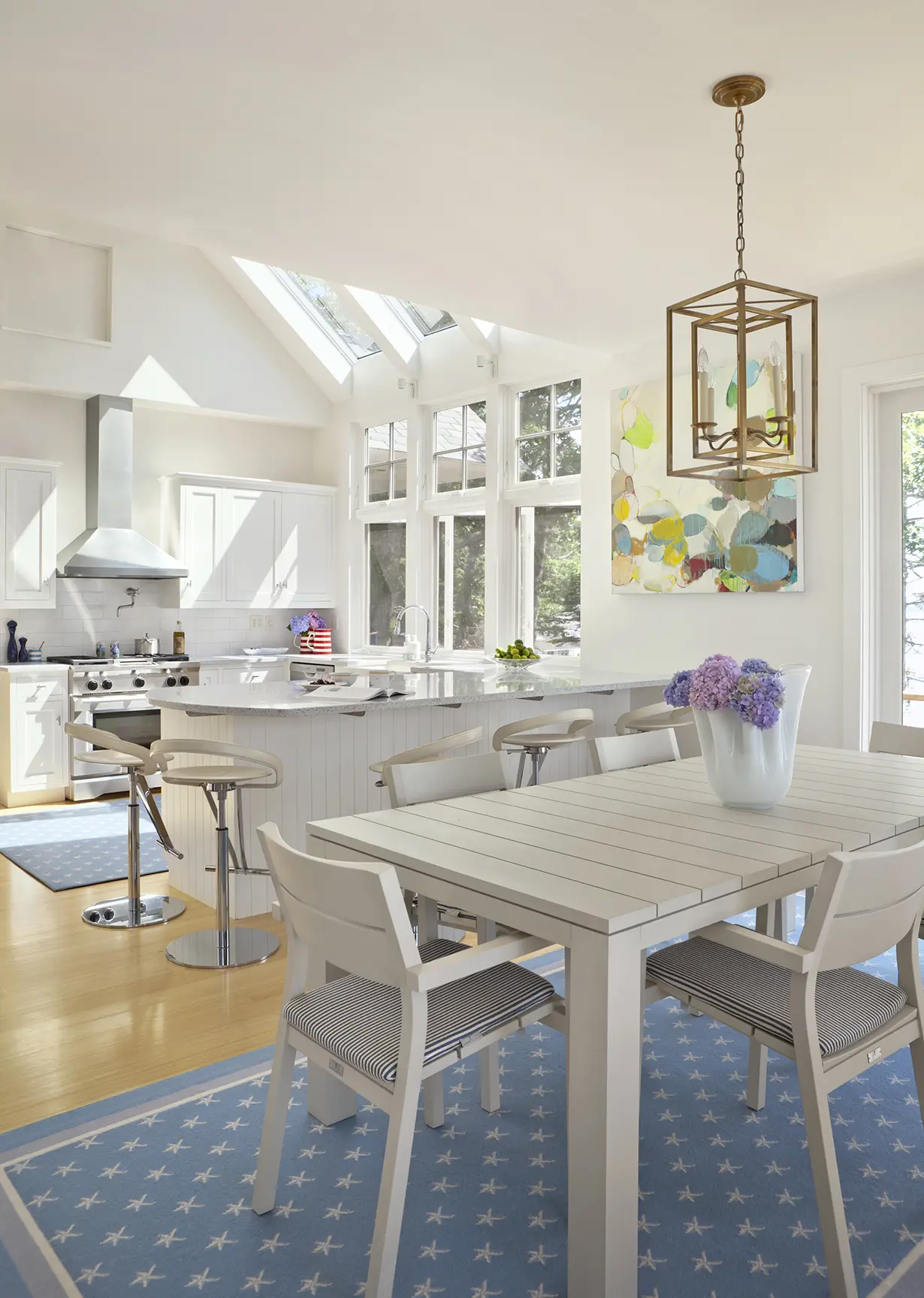 Large kitchen and dining area with natural light and contemporary pendant