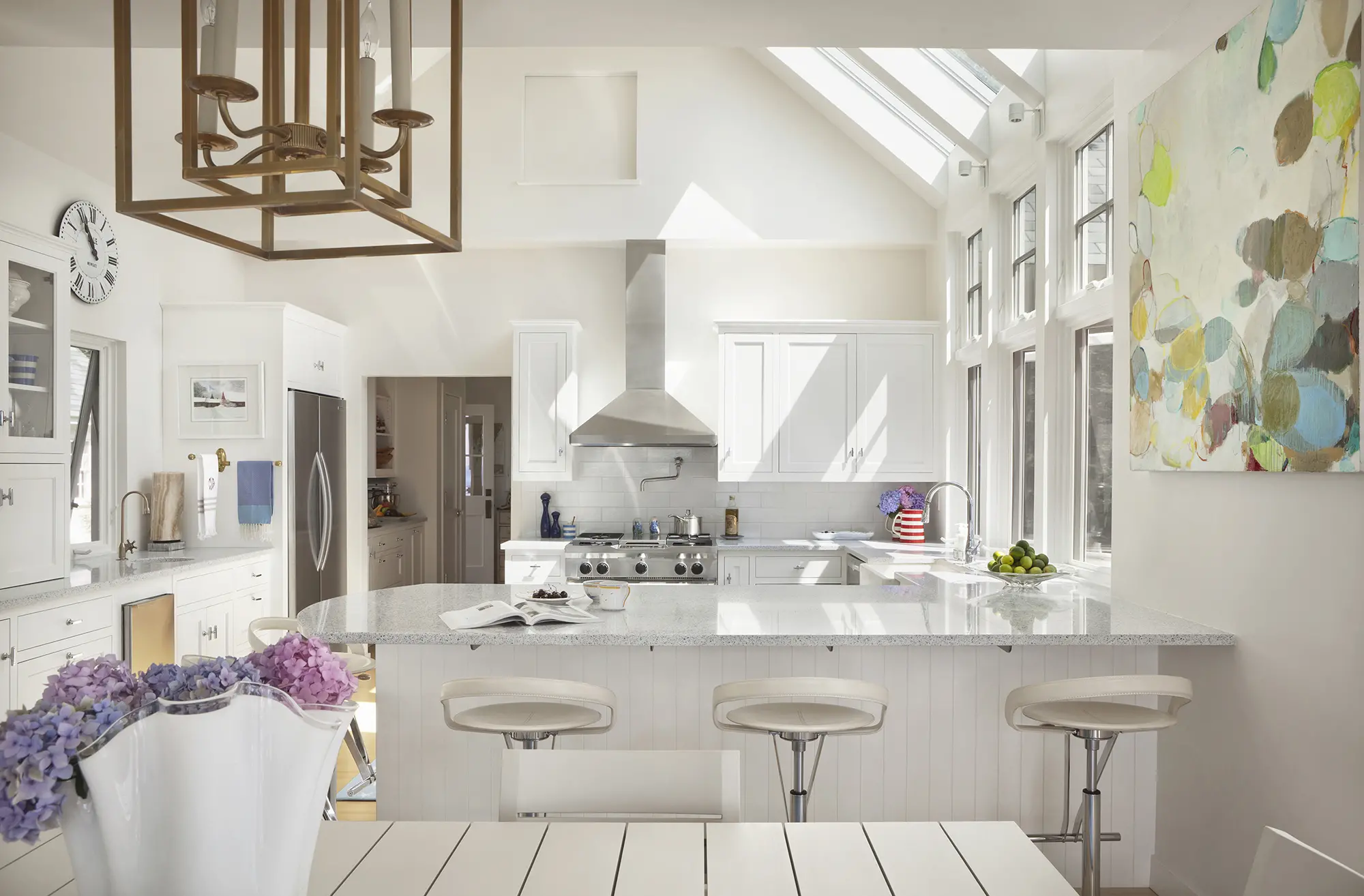 Bright white kitchen with floral accents, modern theme, and new appliances
