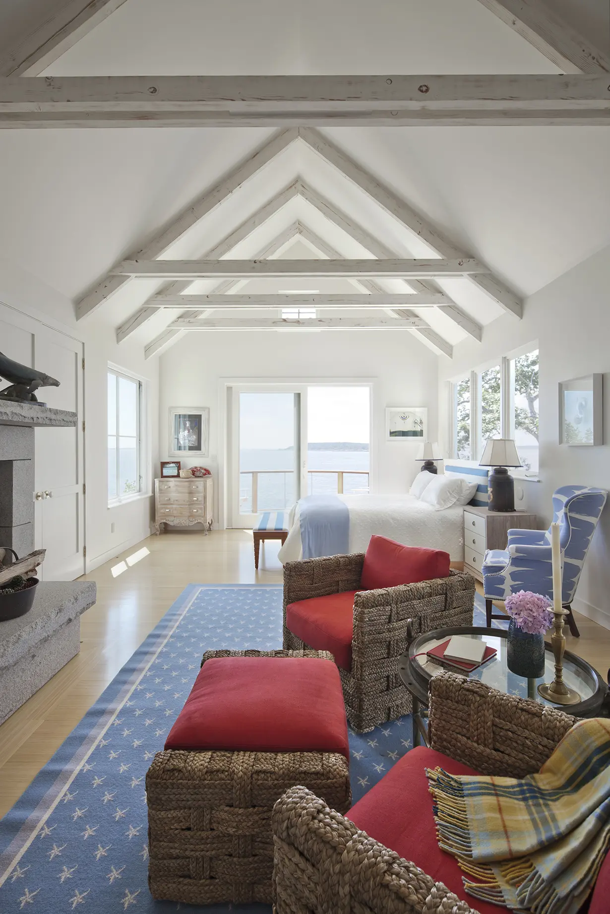 Bright bedroom with sitting area, fireplace, and cathedral ceilings.