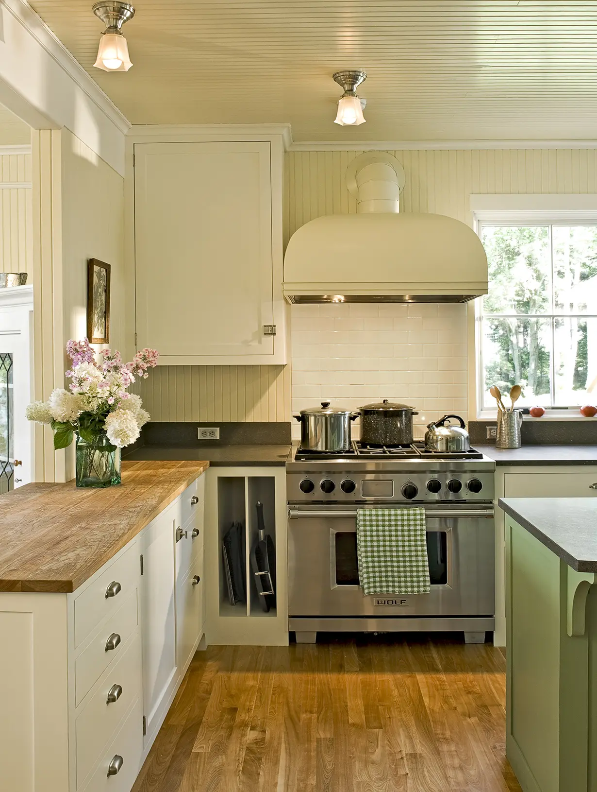 Wood countertop with wood paneled walls and ceiling, and vintage inspired stove top