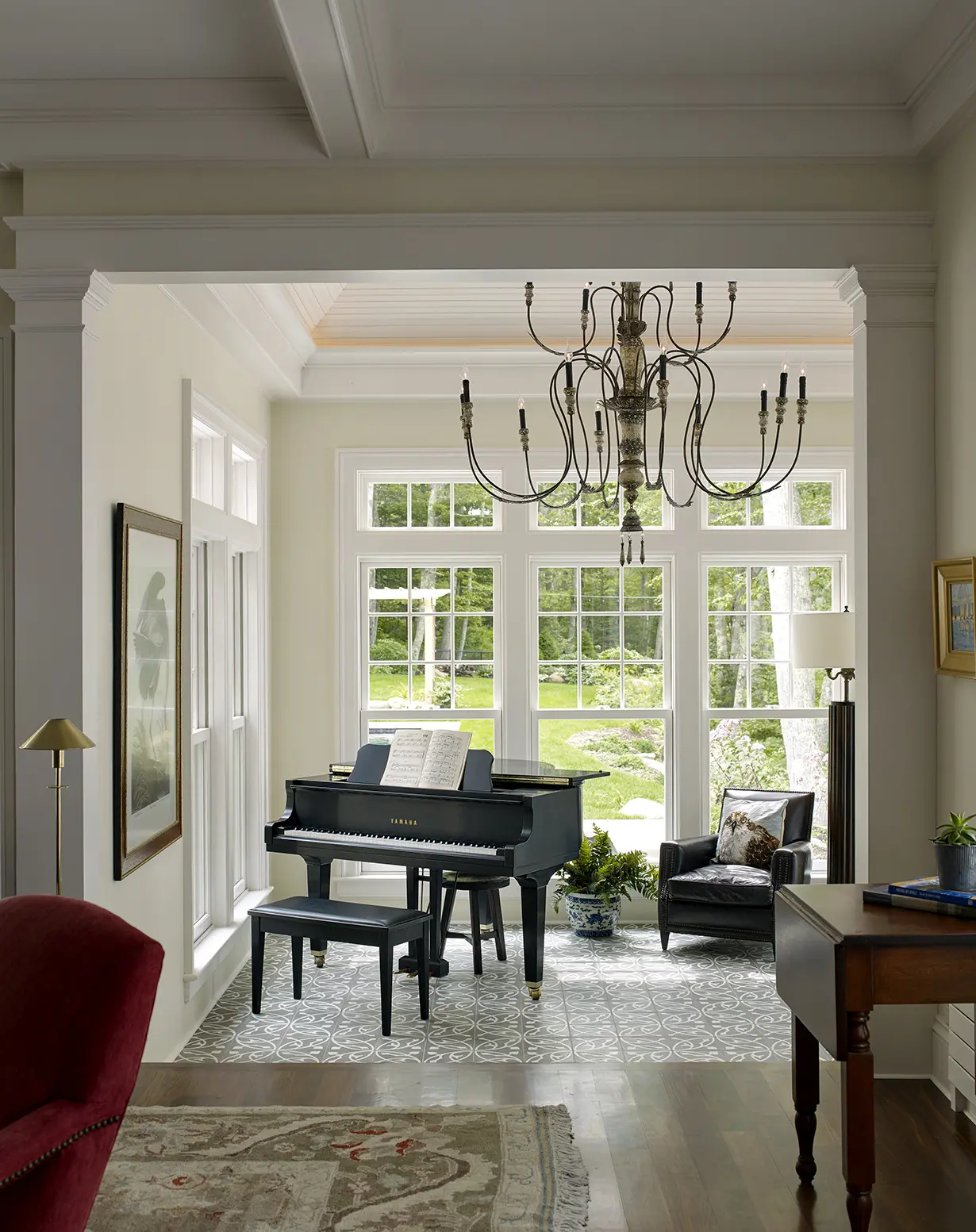 Grand piano with large picture windows and iron chandelier