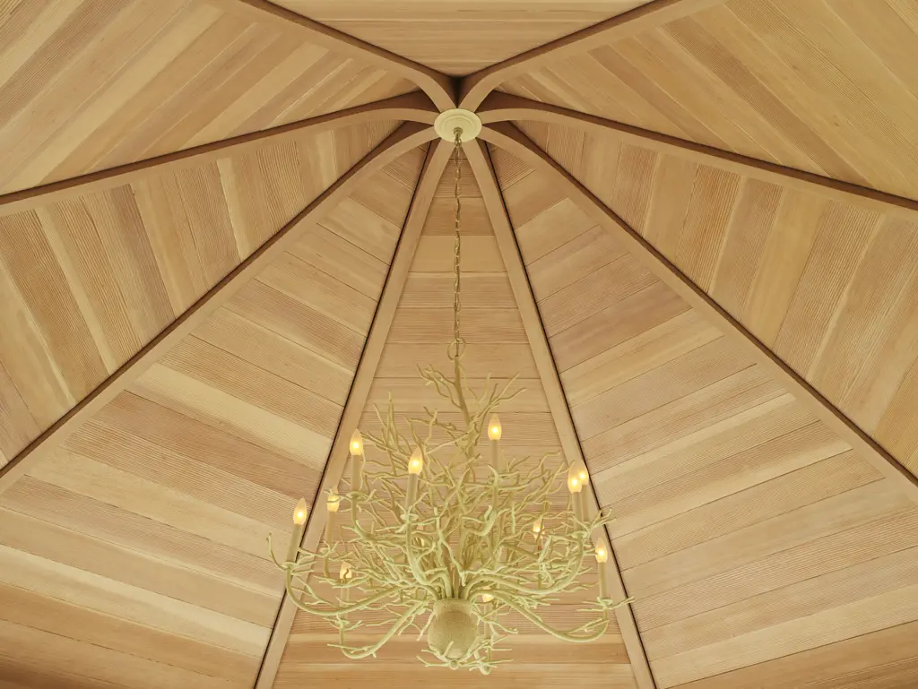 Coral inspired chandelier with arched wood detailed ceiling