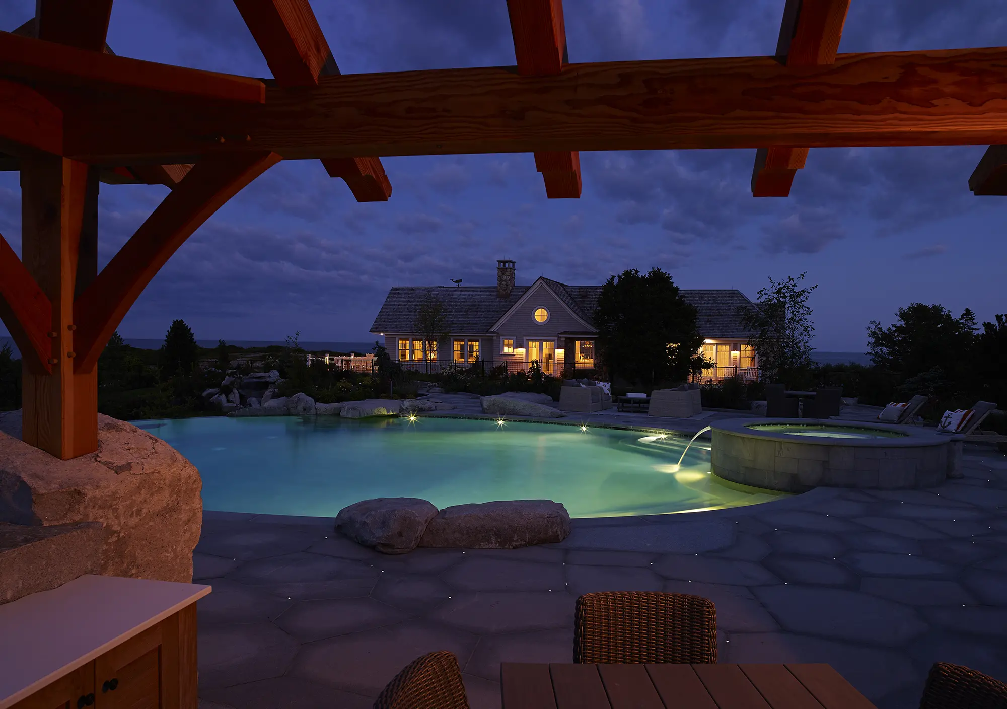 Evening view of Whales Watch and the inground hot tub and pool from the pergola
