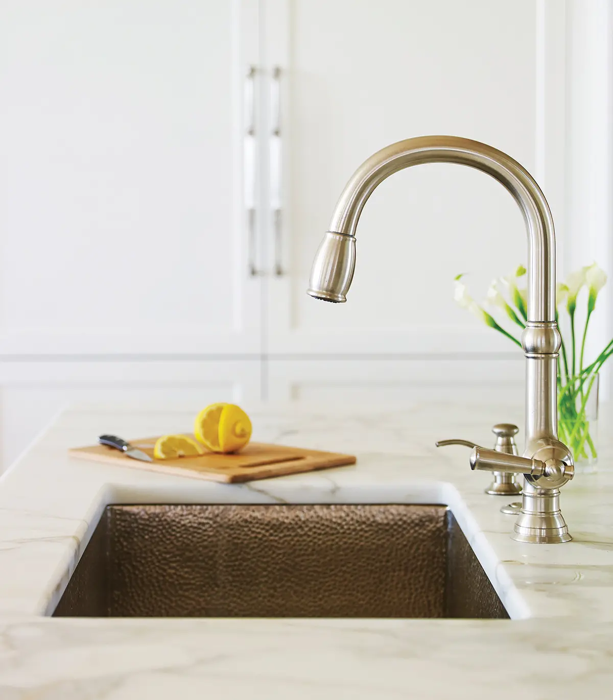 A modern, sleek silver faucet with hammer finish basin and marble countertops in the kitchen at Whales Watch