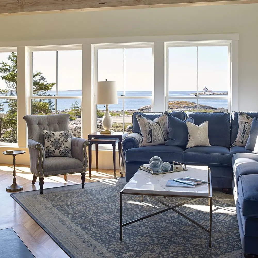 The living room with large blue sectional and coastal views
