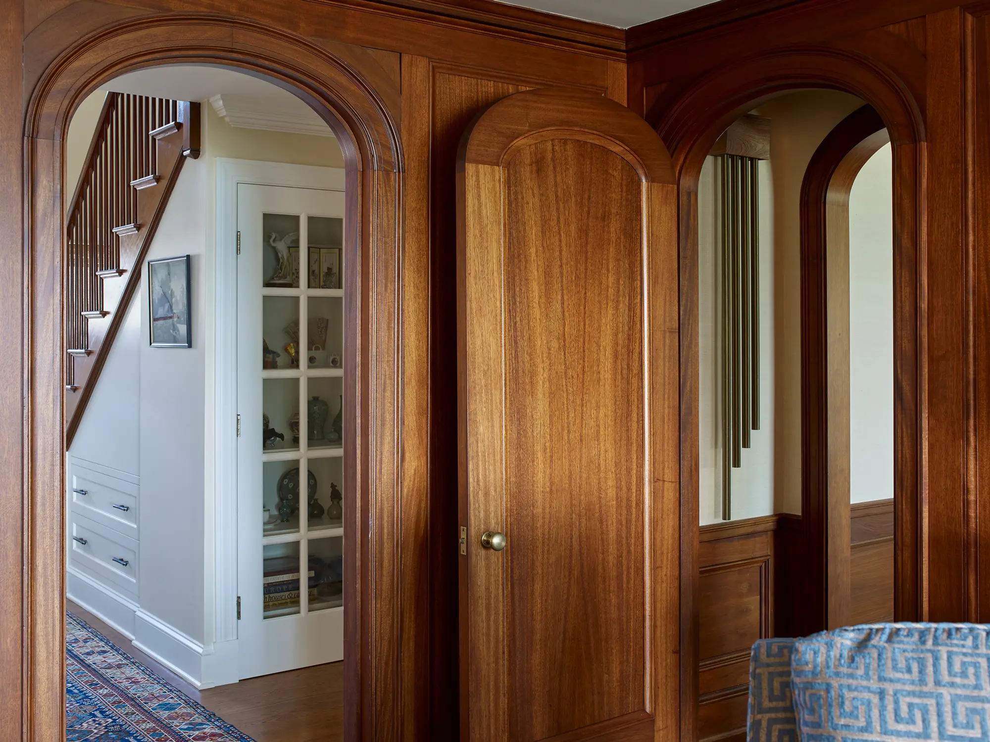 Rounded doorways with views of the built-in bookshelf with glass door.