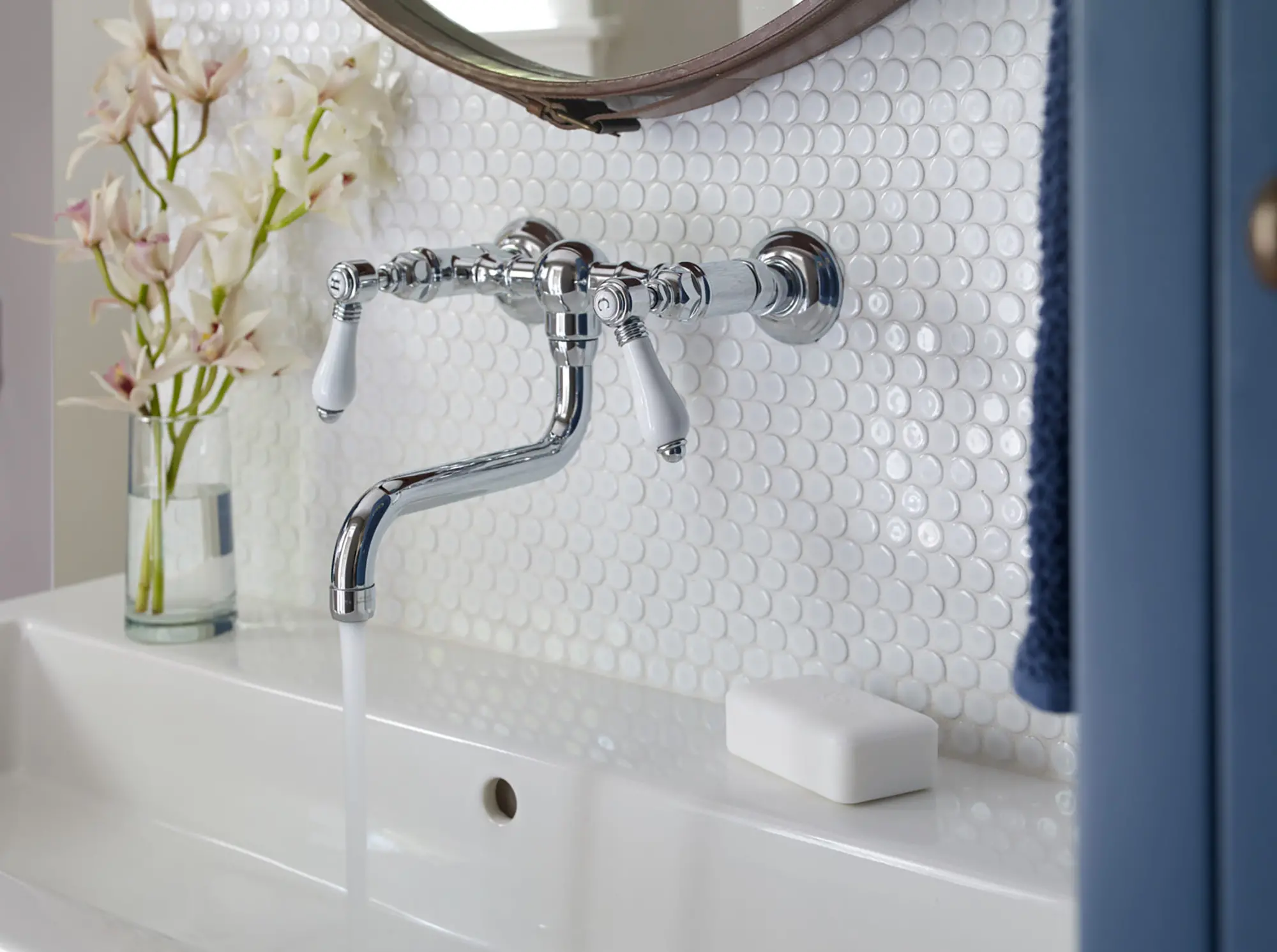 Silver hardware with round tile backsplash in the laundry room at Casino Cottage