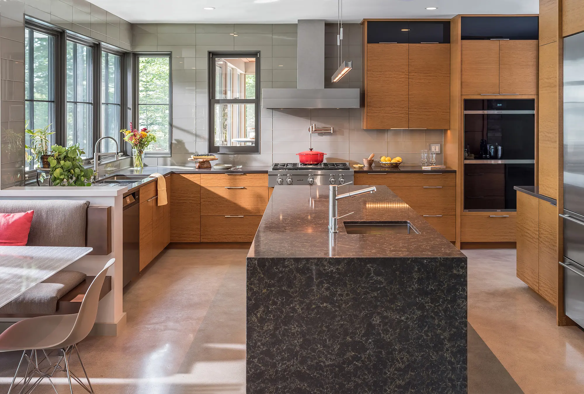 A large contemporary kitchen with a lot of cabinet space and granite island