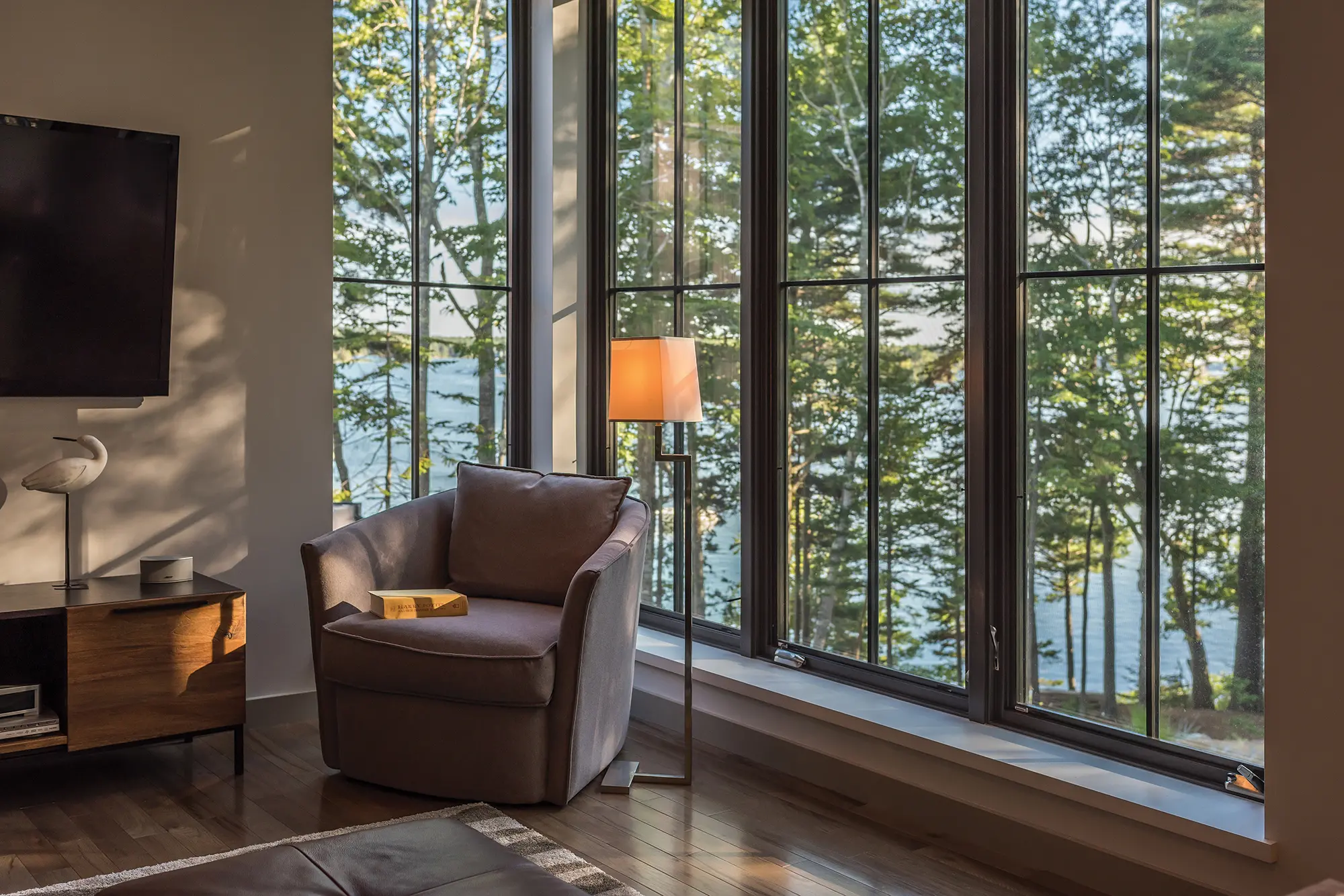 A cozy chair tucked by the large windows along the living room with views of the coast for miles - the perfect reading and relaxing spot.