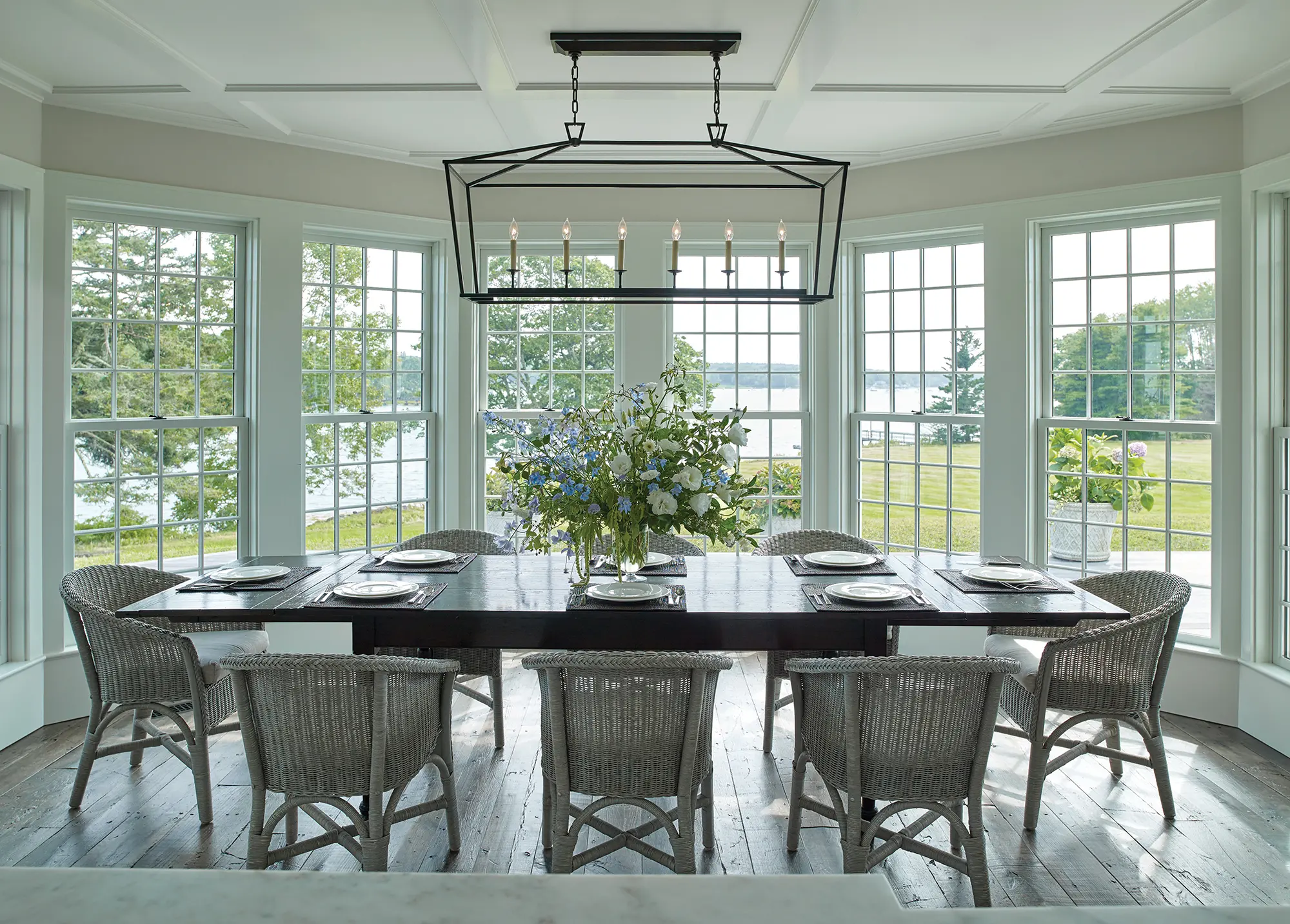 Large dining area with farmhouse style lighting, and 180 degrees of unobstructed coastal Maine views.