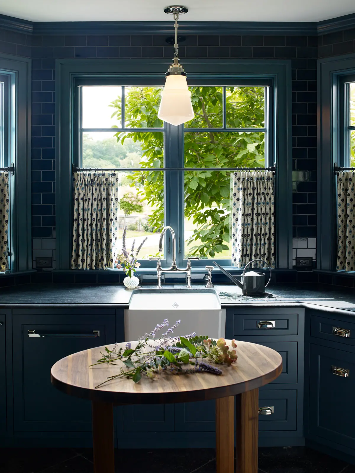 A view of the kitchen area that highlights the unique light fixture and deep blue theme.