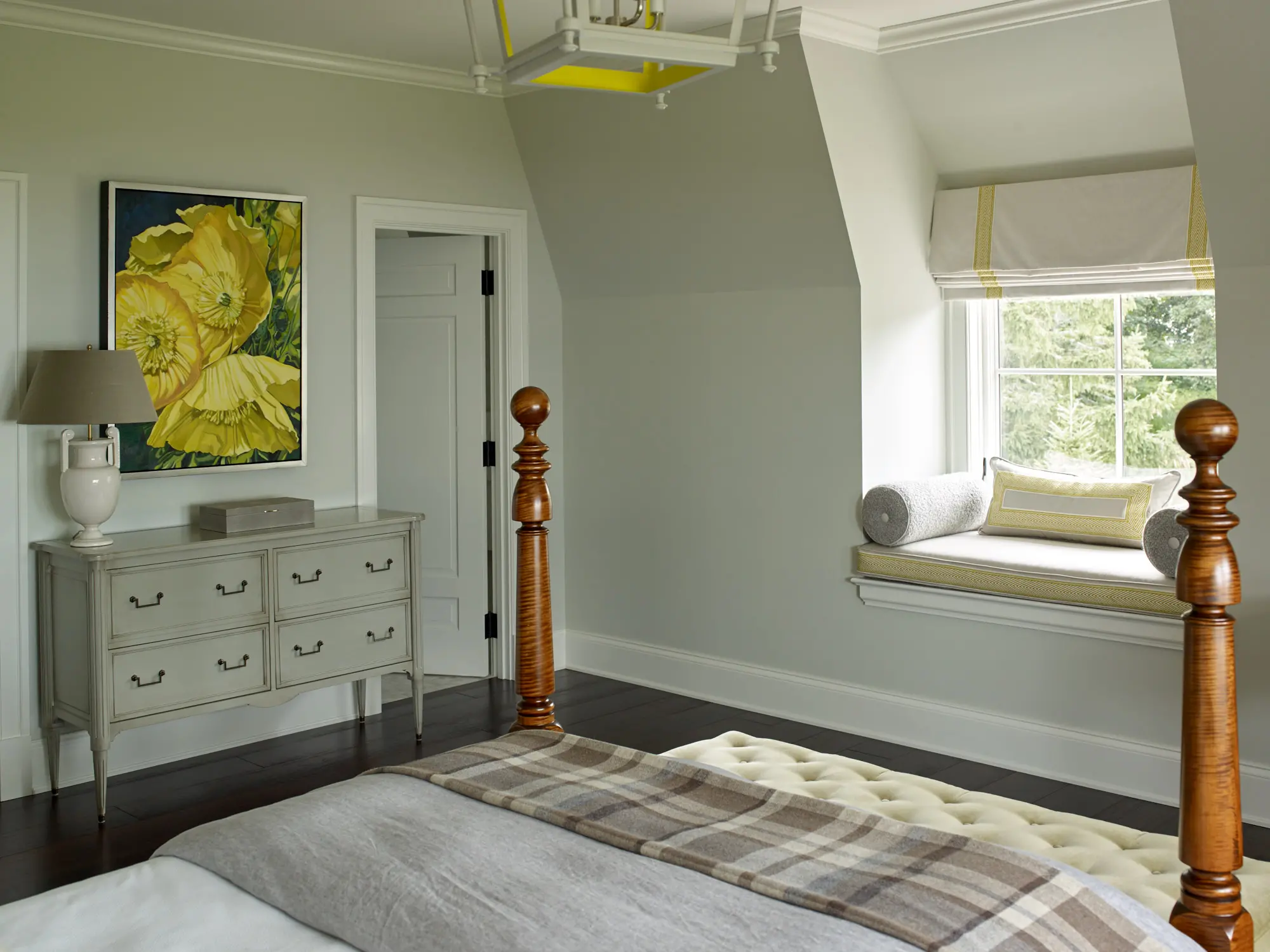 Spacious bright bedroom with yellow accents and a comfy window seat.