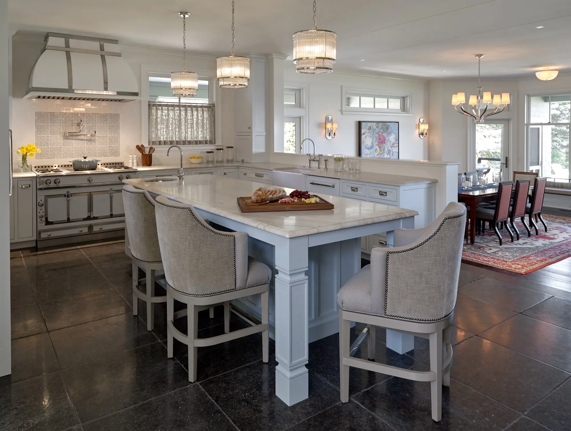 Large open concept kitchen and dining area with tile flooring and white marble countertops.
