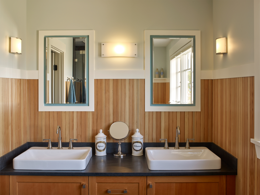 Wood paneled bathroom with double sinks and built in mirrors