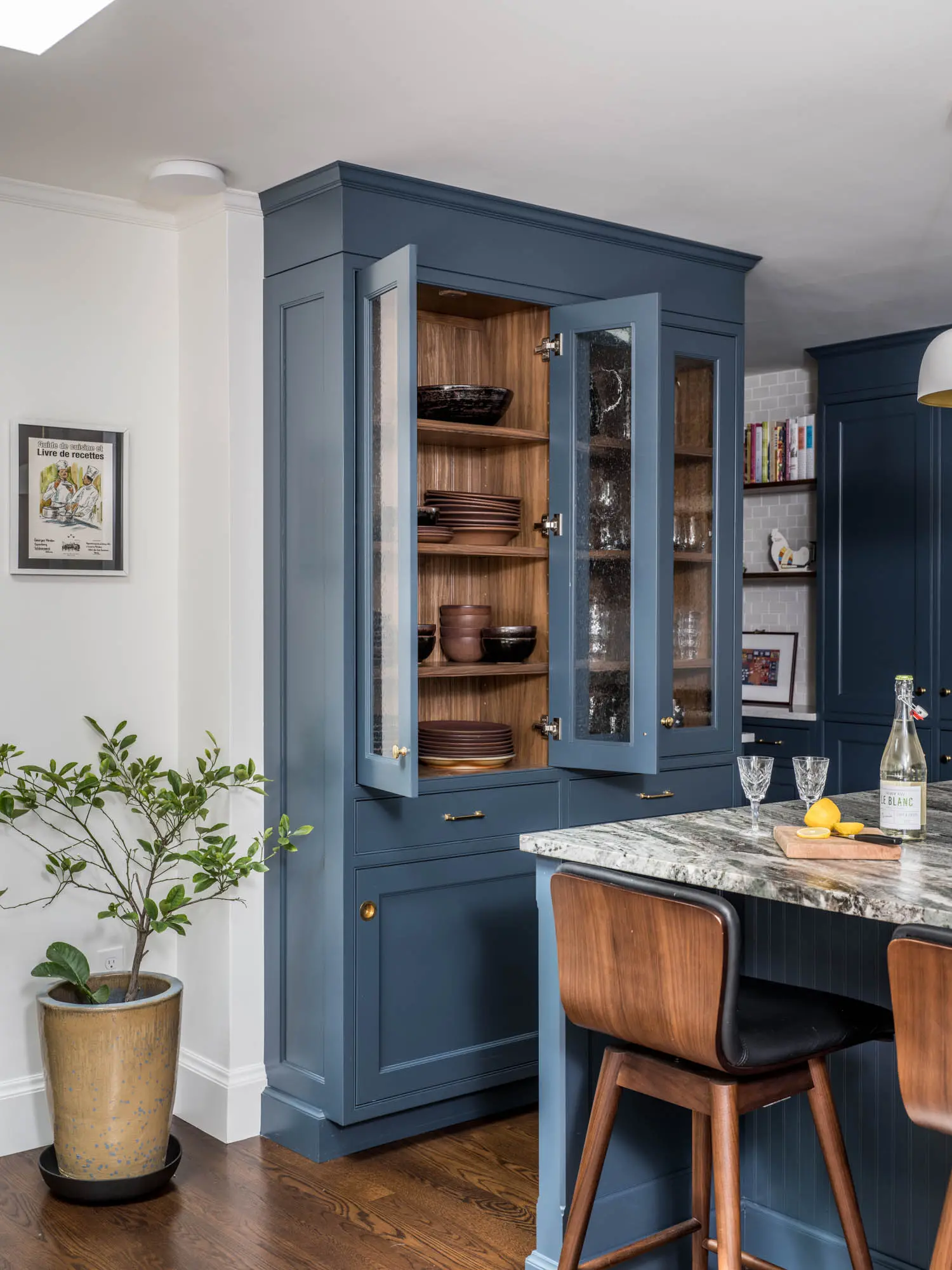 Blue cabinets and kitchen island with marble counter top