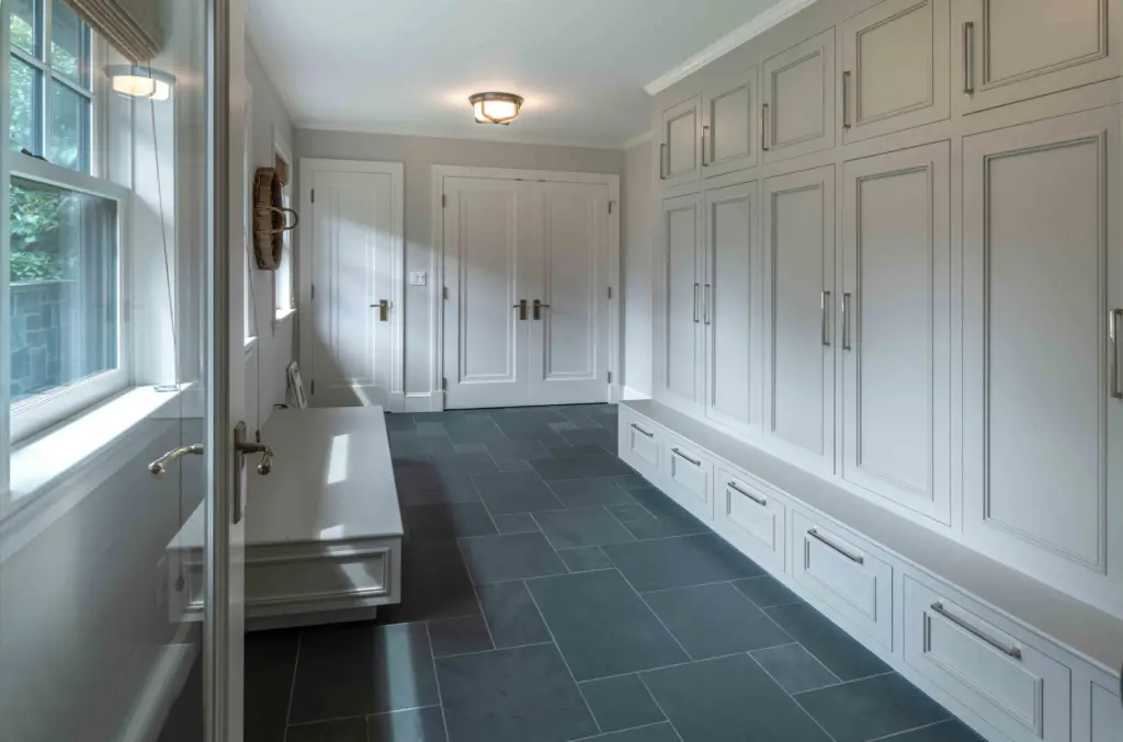 Stone tiled mudroom with custom cabinets and drawers