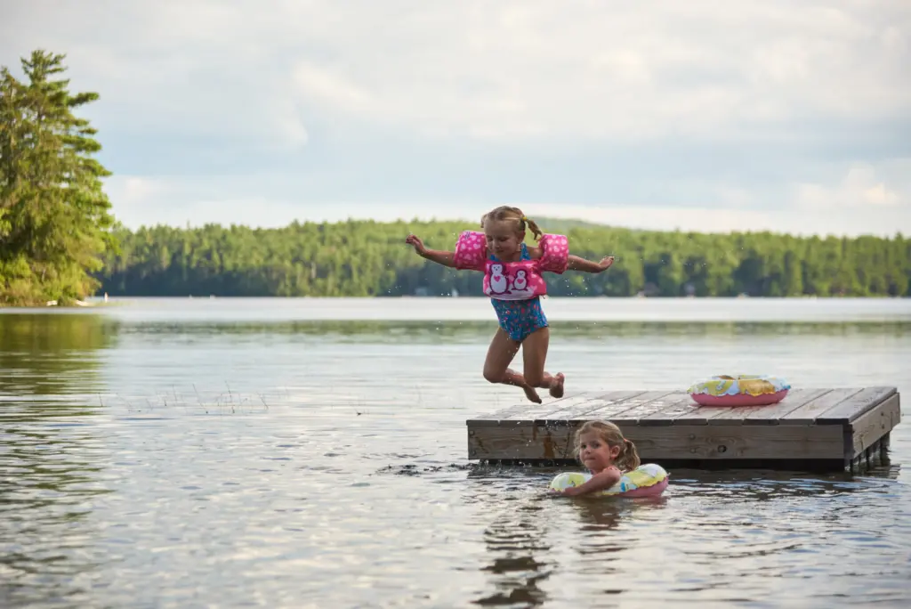Children jumping off floating dock at Cozy Bear property