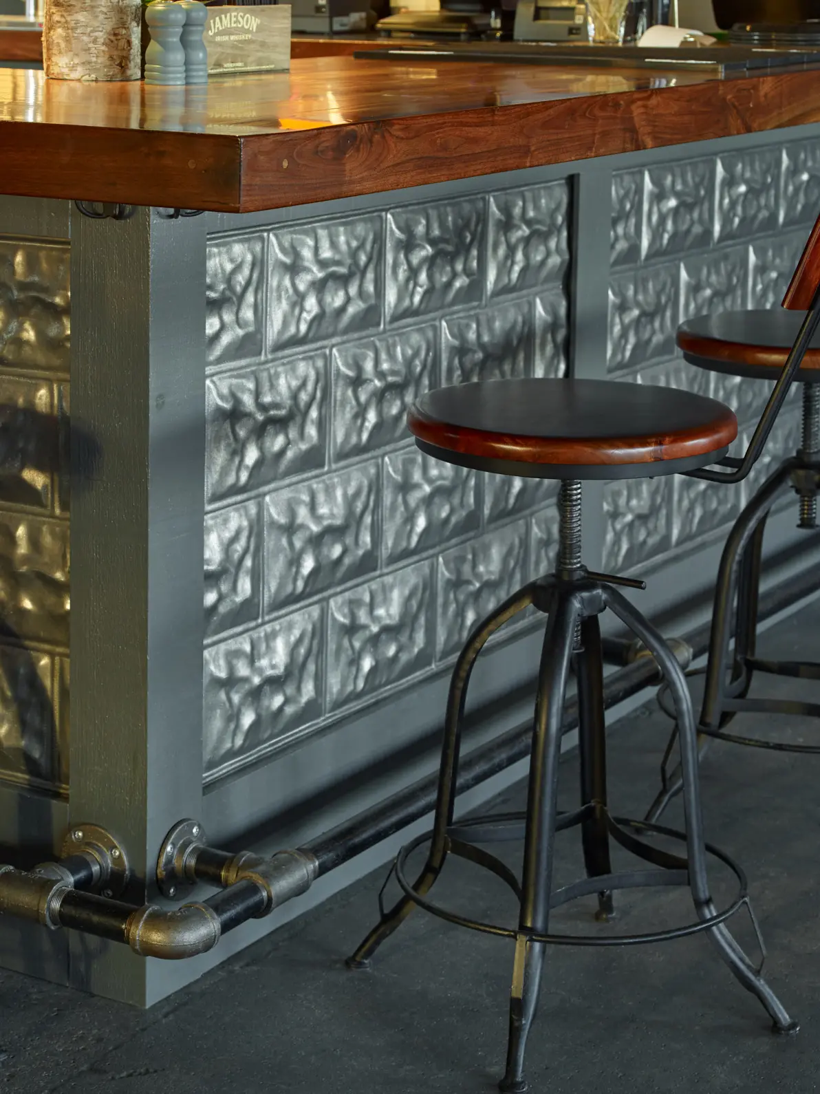 Industrial style bar area with pipe and metal finishings.
